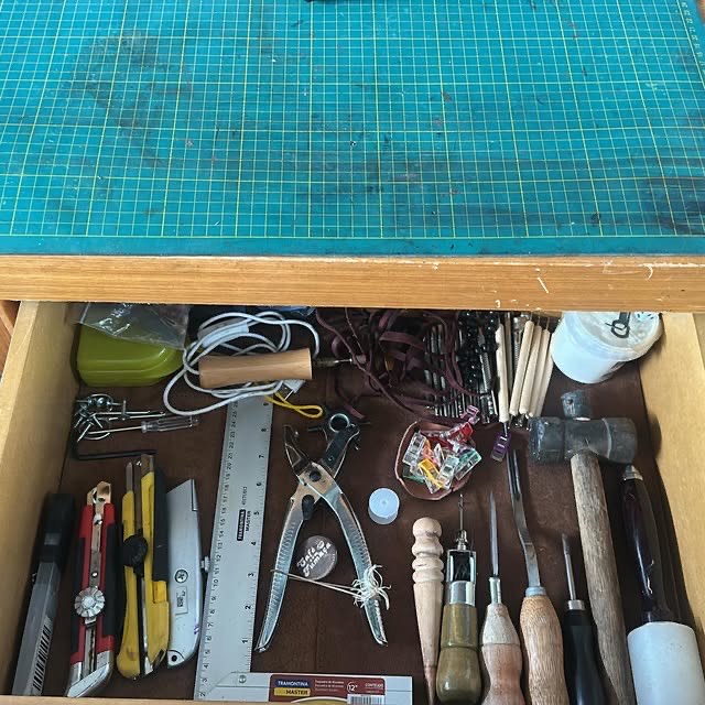 Tooling stamps, punches and a mallet kept in the bench drawer.