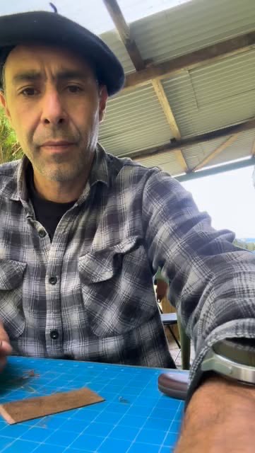 The maker at his workbench under a tin roof.