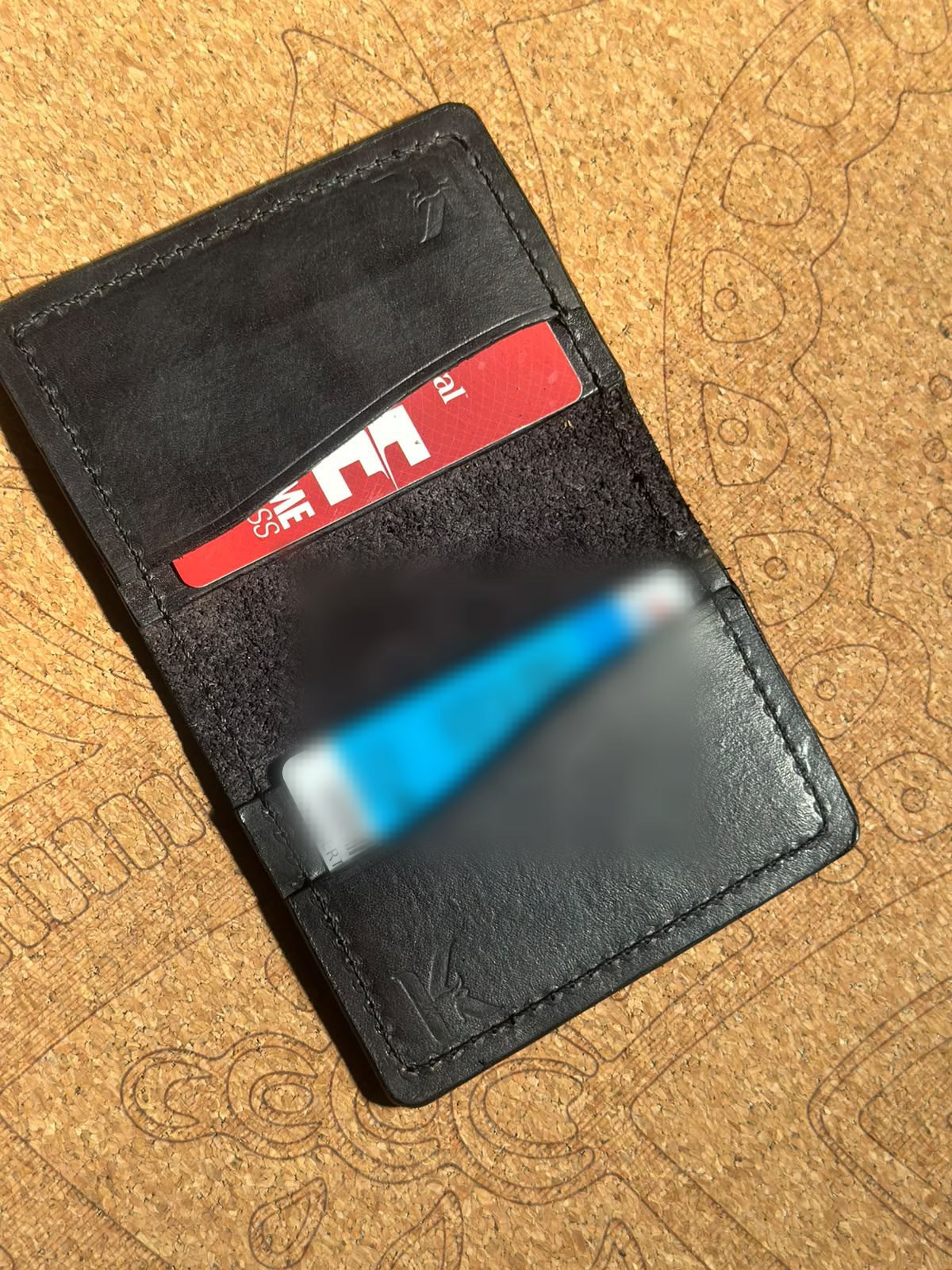 An open Kaíru wallet with cards in its inner suede dividers.